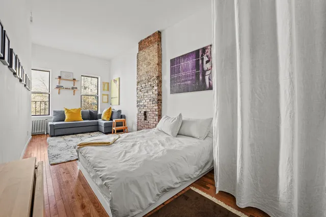 a living room with furniture and a painting on the wall