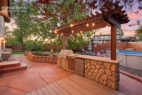 a view of a patio with couches and table with wooden floor and fence