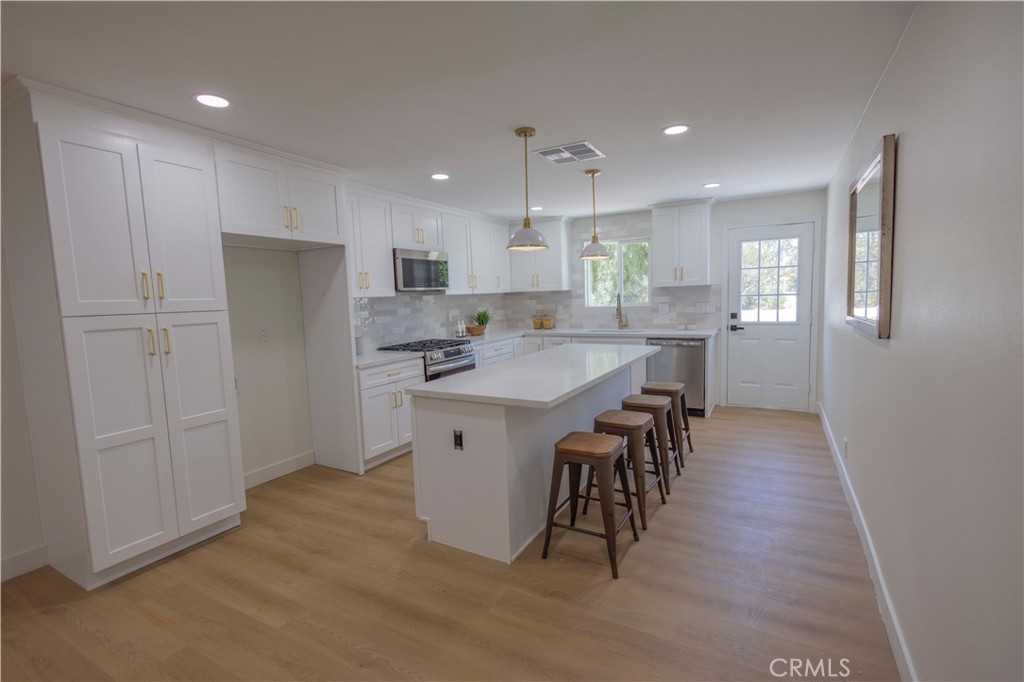 20530 Clark Street Perris, CA 92570 - Photo 7 of 25 a kitchen with kitchen island wooden cabinets and refrigerator