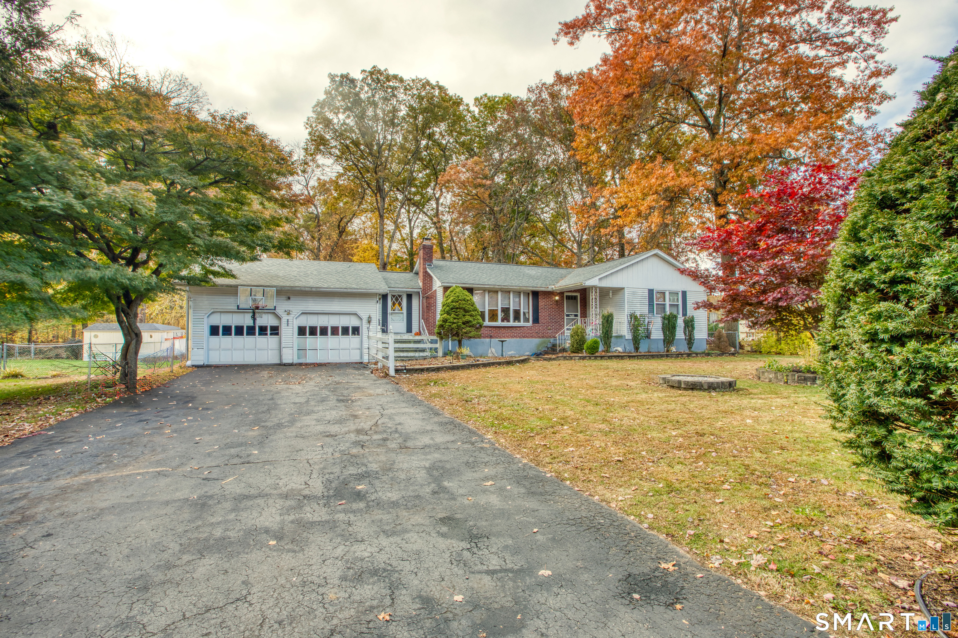 a view of house with outdoor space and trees in the background