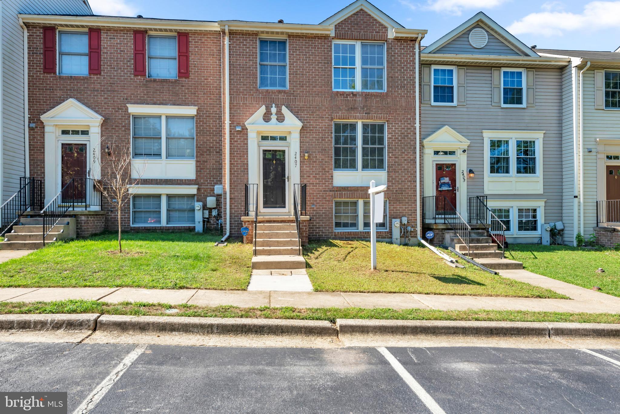 2407 Warm Spring Way Odenton, MD 21113 - Photo 2 of 45 a view of a brick house with a yard plants and large tree