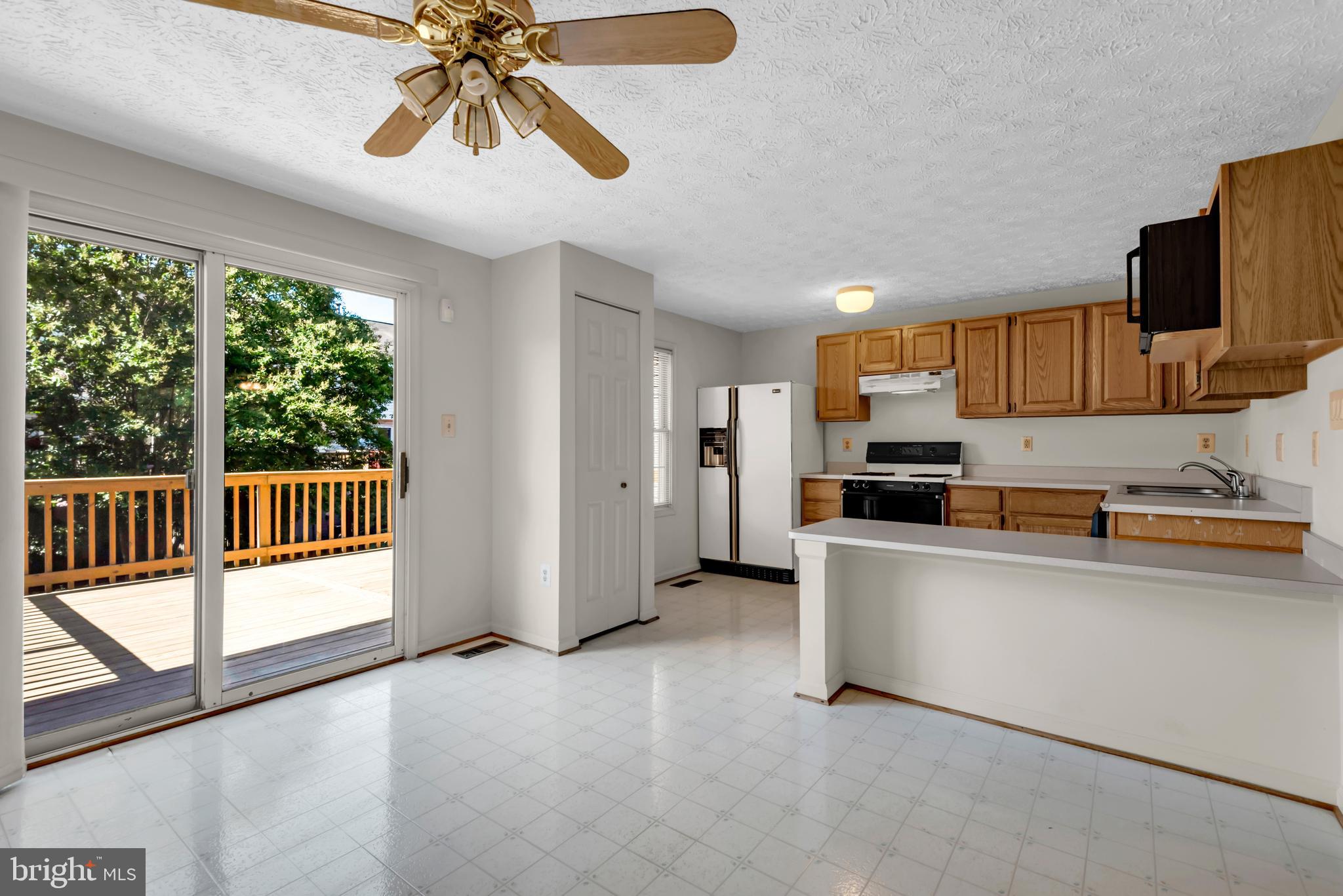 2407 Warm Spring Way Odenton, MD 21113 - Photo 7 of 45 a kitchen with stainless steel appliances a microwave a stove and white cabinets