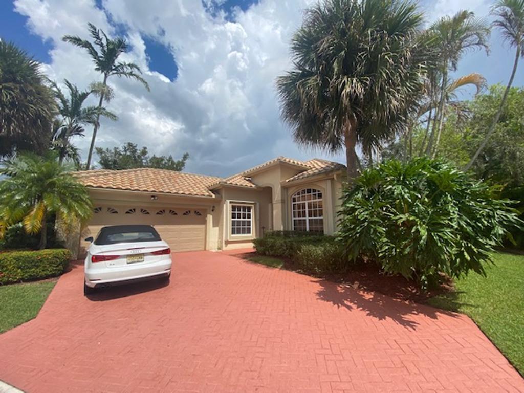 a car parked in front of a house with a yard