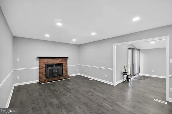 an empty room with wooden floor and ceiling fan