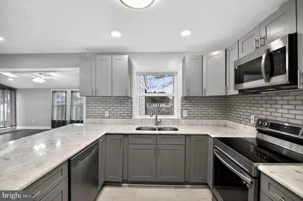 a kitchen with stainless steel appliances granite countertop a sink and a stove