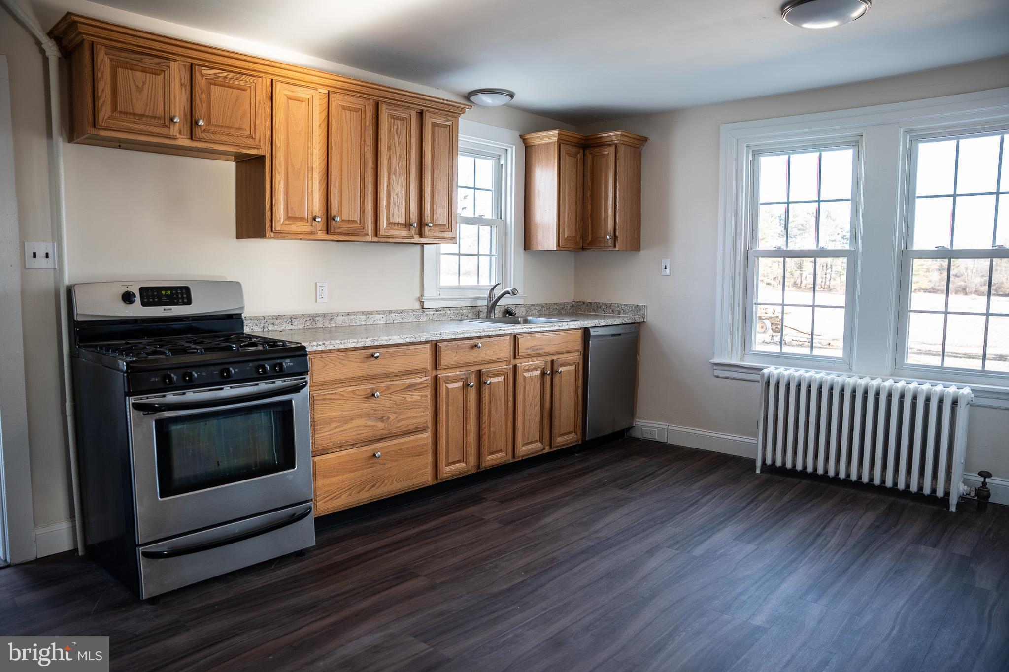395 Bishop Hollow Road, Unit C Newtown Square, PA 19073 - Photo 11 of 28 a kitchen with stainless steel appliances a stove a sink and cabinets