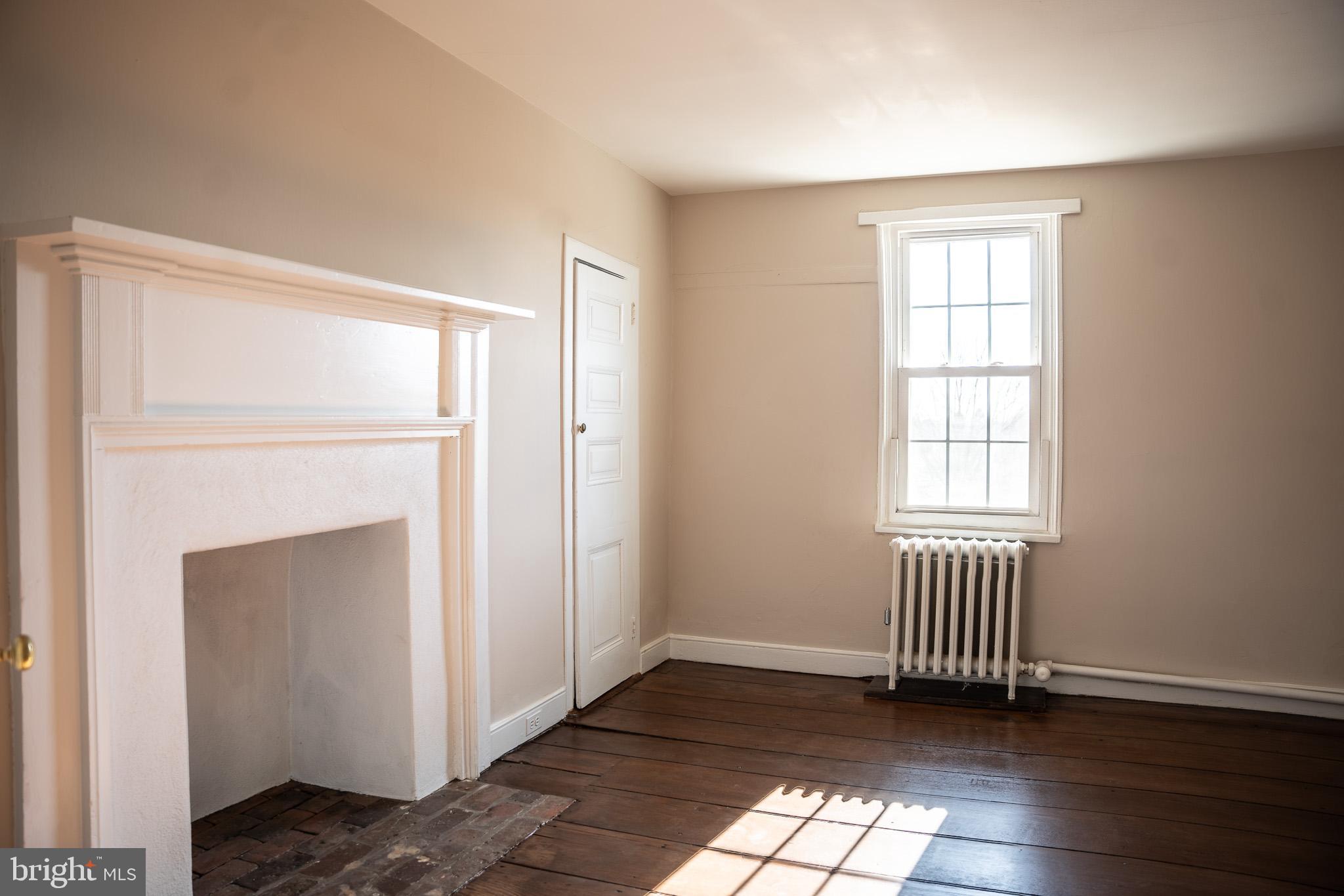 395 Bishop Hollow Road, Unit C Newtown Square, PA 19073 - Photo 22 of 28 a view of an empty room with wooden floor and a window