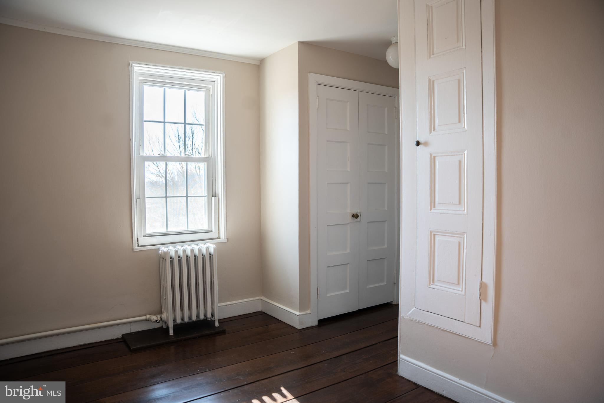 395 Bishop Hollow Road, Unit C Newtown Square, PA 19073 - Photo 25 of 28 an empty room with wooden floor and windows