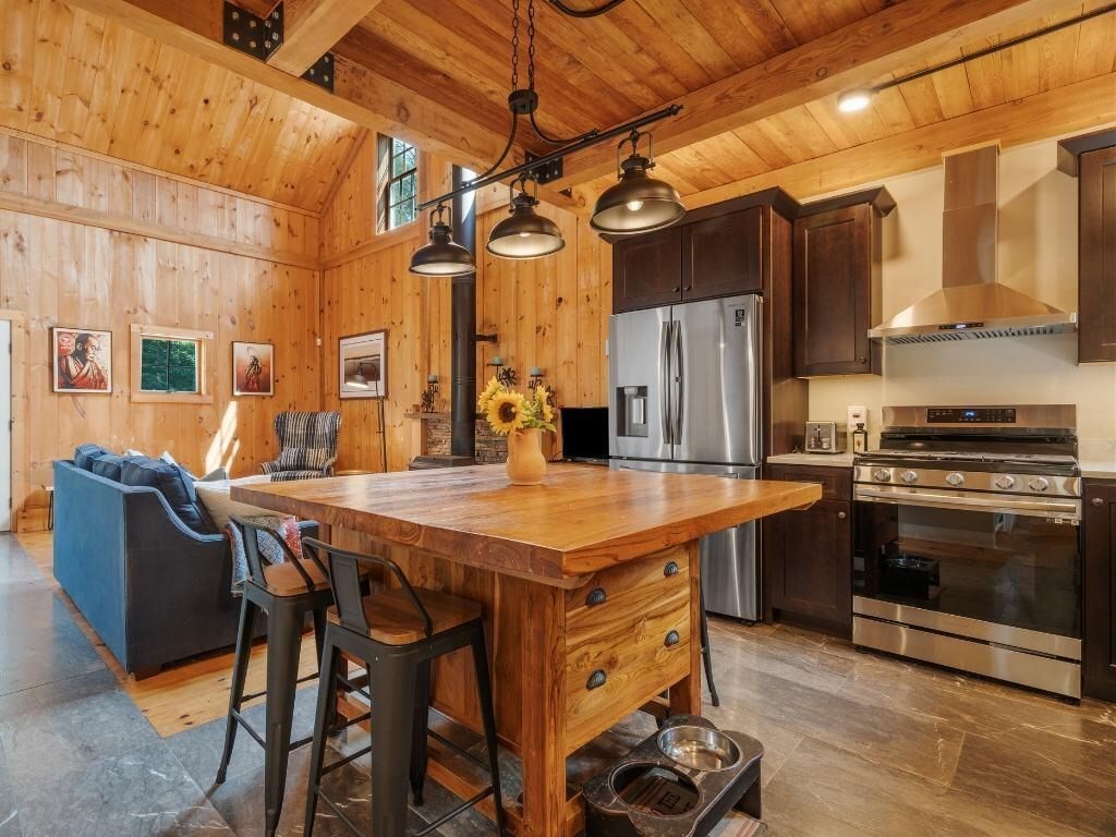 3 Jeffrey's Neck Road Ipswich, MA 01938 - Photo 38 of 42 a kitchen with stainless steel appliances granite countertop a stove a refrigerator a kitchen island a couches and chairs with wooden floor