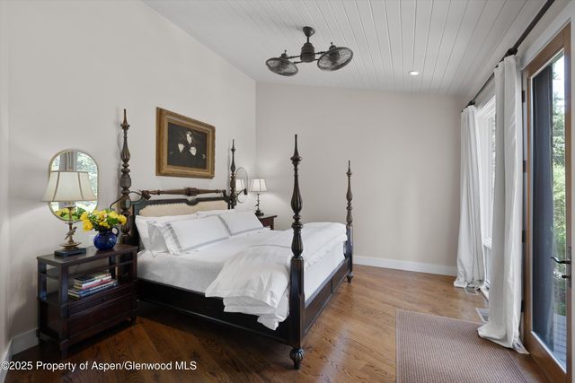a bedroom with a bed wall painting and a window