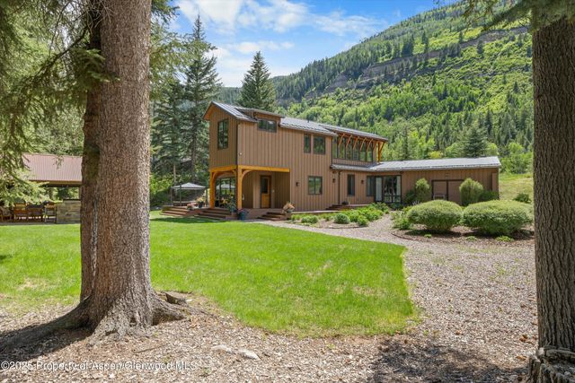 a view of a house with backyard and a tree