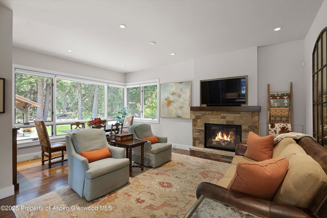 a living room with furniture fireplace and a large window