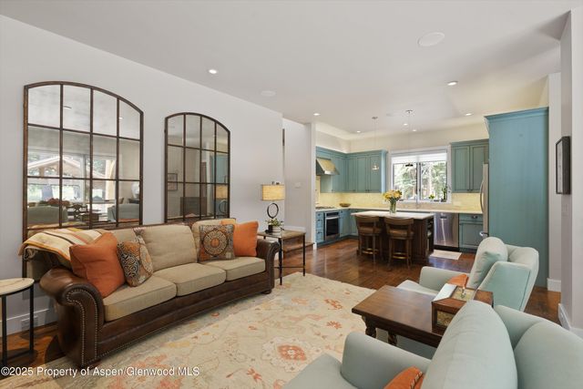 a living room with furniture kitchen view and a large window
