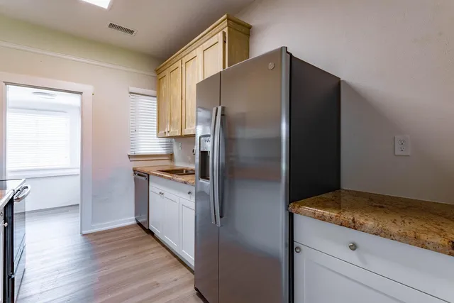 a kitchen with a refrigerator and a stove top oven