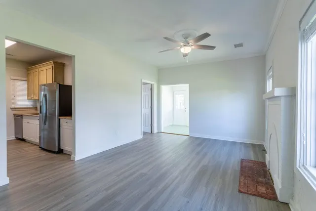 a view of an empty room with a window and wooden floor