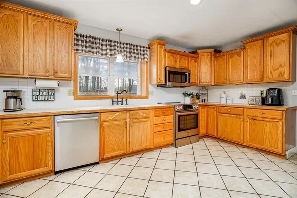 a view of a dining room with furniture a chandelier and kitchen view