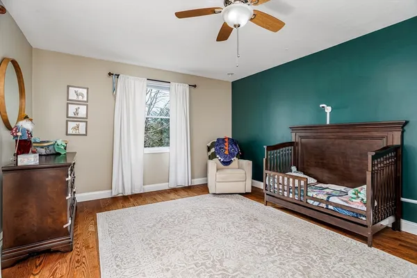 a bedroom with a large bed a chandelier and dresser