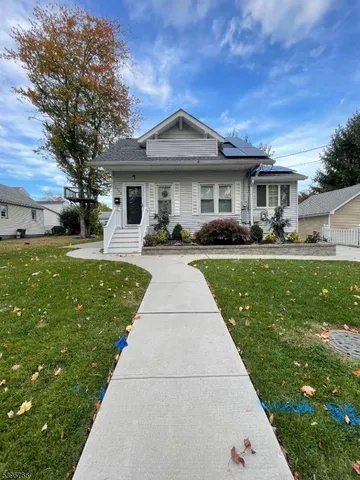 a front view of a house with a garden and trees