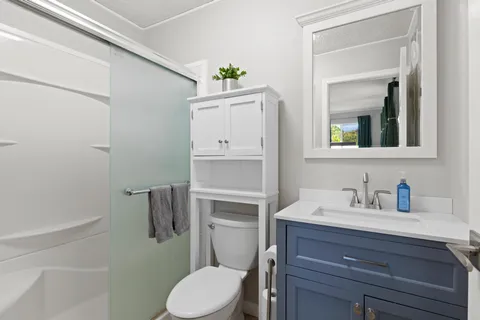 a bathroom with a sink vanity mirror and toilet