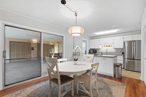 a kitchen with a dining table chairs stainless steel appliances and cabinets