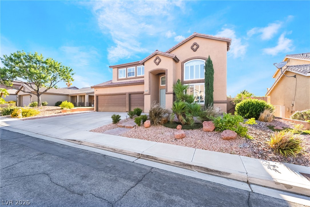 261 Timber Hollow Street Henderson, NV 89012 - Photo 5 of 51 A gracefully designed exterior boasts a two-car garage and meticulously landscaped front yard with desert-friendly plants.