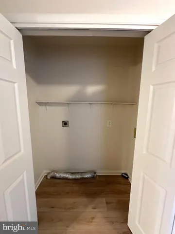 a living room with stainless steel appliances wooden floor and furniture
