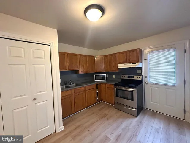 a kitchen with granite countertop a stove and a wooden floors