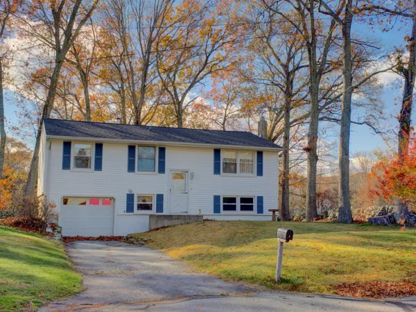 a front view of house with yard and trees around