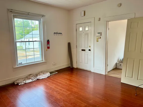 an empty room with wooden floor and a window