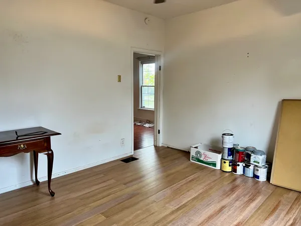 an empty room with wooden floor and furniture