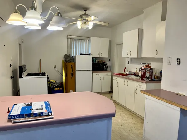 a kitchen with kitchen island granite countertop a sink cabinets and refrigerator
