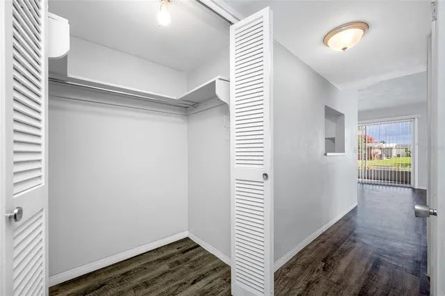 a view of a hallway with wooden floor and cabinet