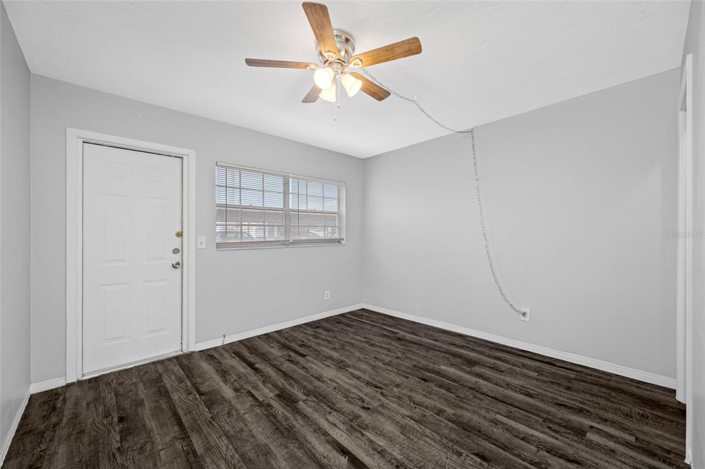50 Liberty Way, Unit 10 Palm Harbor, FL 34684 - Photo 15 of 23 a view of a room with wooden floor and a ceiling fan