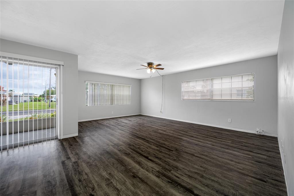 50 Liberty Way, Unit 10 Palm Harbor, FL 34684 - Photo 2 of 23 an empty room with wooden floor and windows