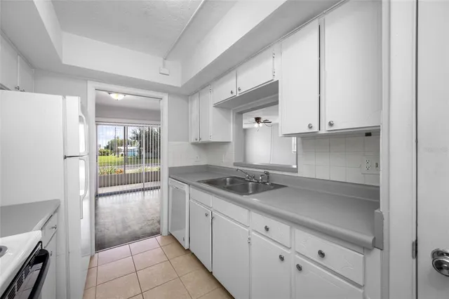 a kitchen with granite countertop a sink and a stove top oven