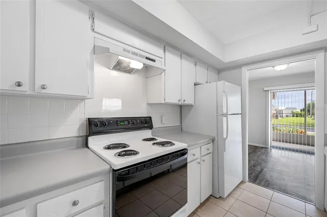 a kitchen with a stove a refrigerator and a cabinets
