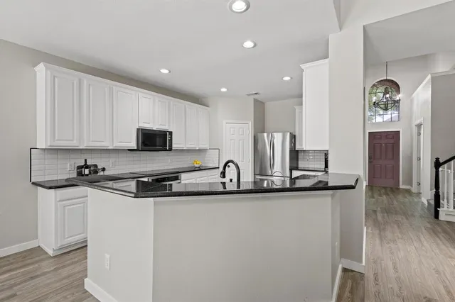 a kitchen with stainless steel appliances granite countertop a sink stove and refrigerator