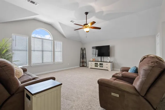 a living room with furniture a flat screen tv and a window
