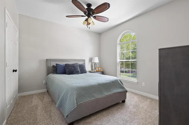 a bedroom with a bed and a large window