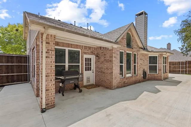 a view of a house with a large window and wooden fence