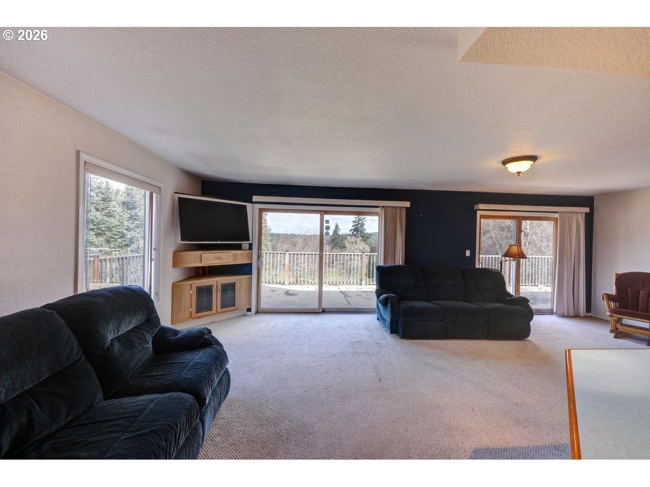 91828 Akerstedt Road Astoria, OR 97103 - Photo 10 of 48 a living room with furniture a flat screen tv and a refrigerator
