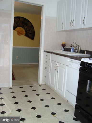 11423 Veirs Mill Road Silver Spring, MD 20902 - Photo 6 of 25 a kitchen with white cabinets and white appliances
