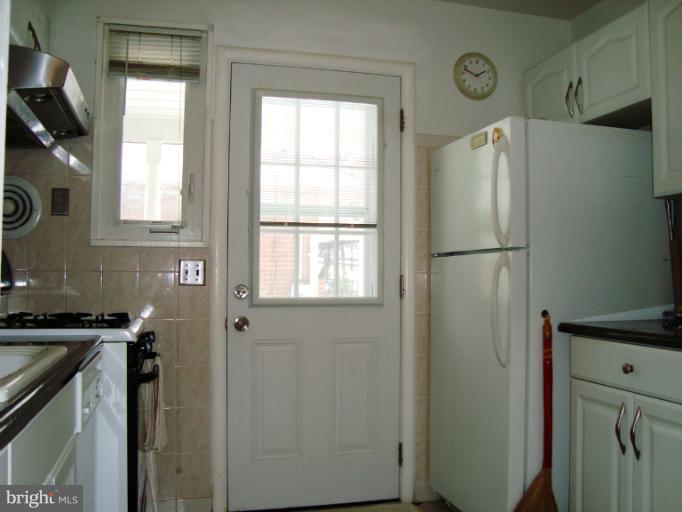 11423 Veirs Mill Road Silver Spring, MD 20902 - Photo 8 of 25 a kitchen with a refrigerator and a stove top oven