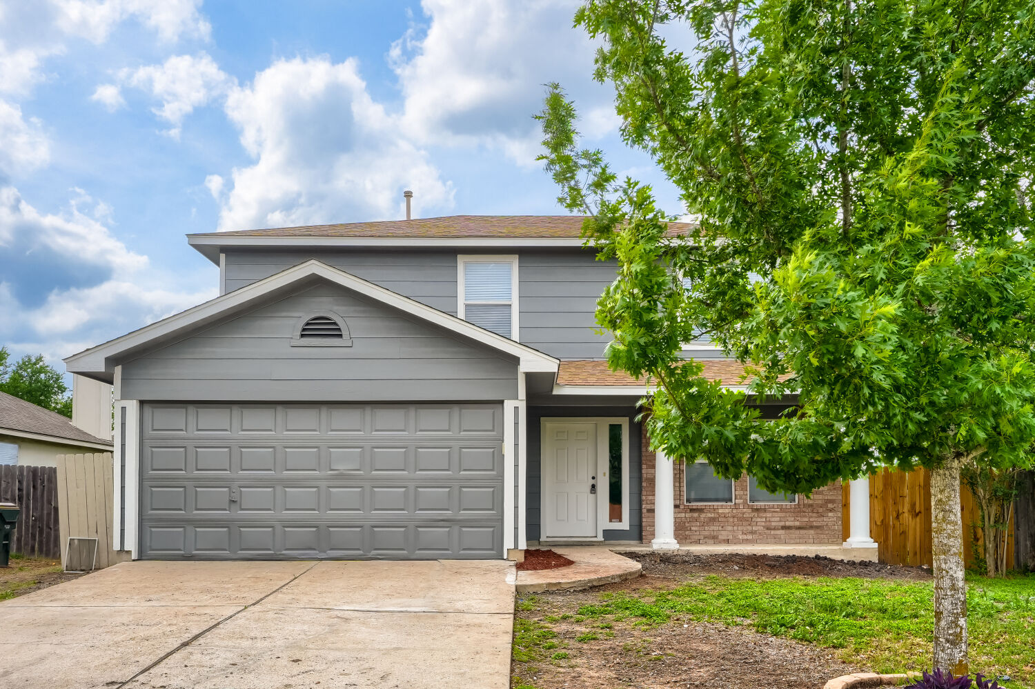 The property features a two-story exterior with grey siding and brick accents, and a two-car garage. Home has no back yard neighbors. Making it very private.