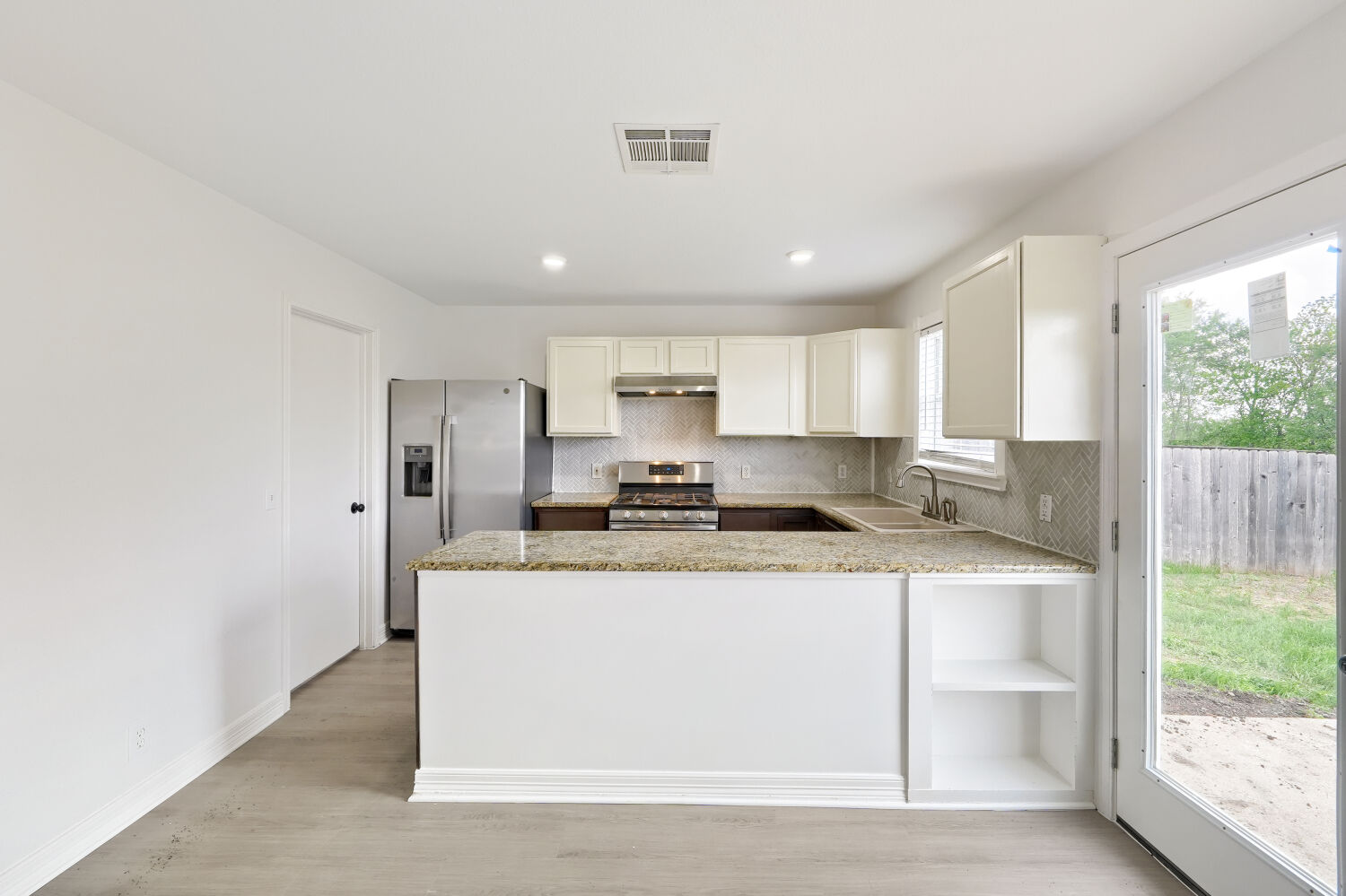 184 Unity Kyle, TX 78640 - Photo 6 of 11 The kitchen features light-colored cabinetry, stainless steel appliances, and granite countertops