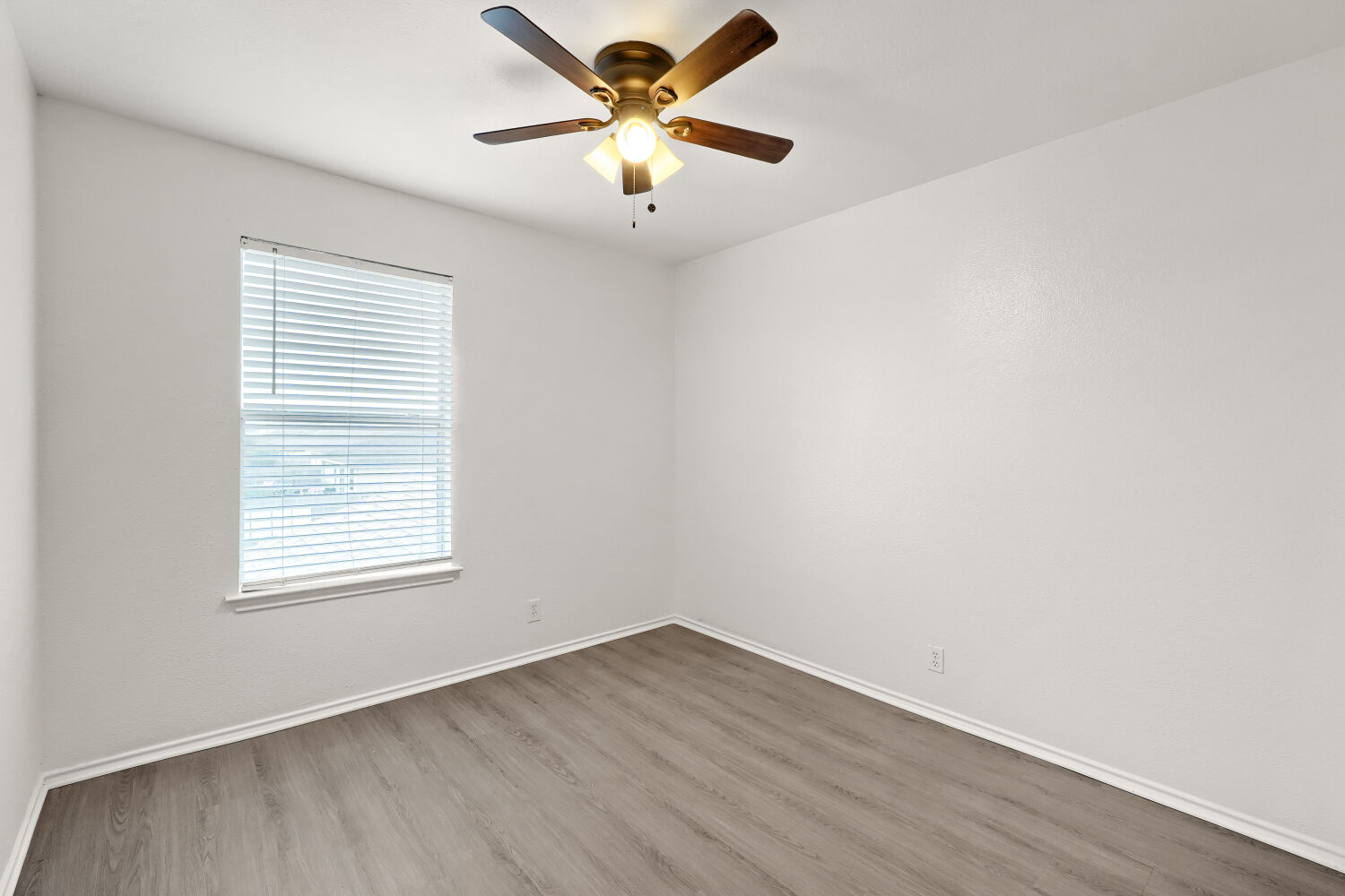 184 Unity Kyle, TX 78640 - Photo 9 of 11 This room features light-colored walls, wood-look flooring, and a ceiling fan with integrated lighting