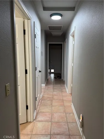 a view of a hallway with wooden floor and a bathroom