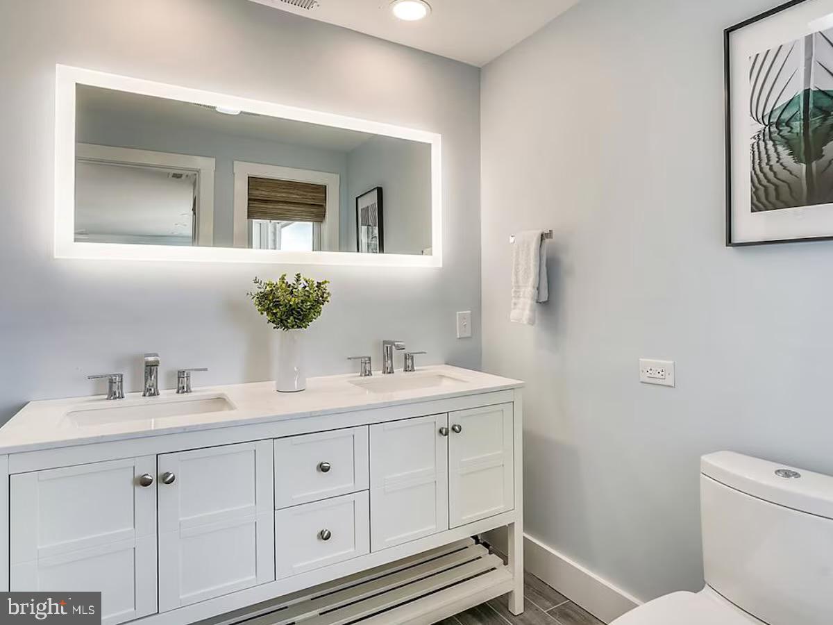 21642 Chicken Point Road Tilghman, MD 21671 - Photo 27 of 63 a bathroom with a toilet sink and mirror