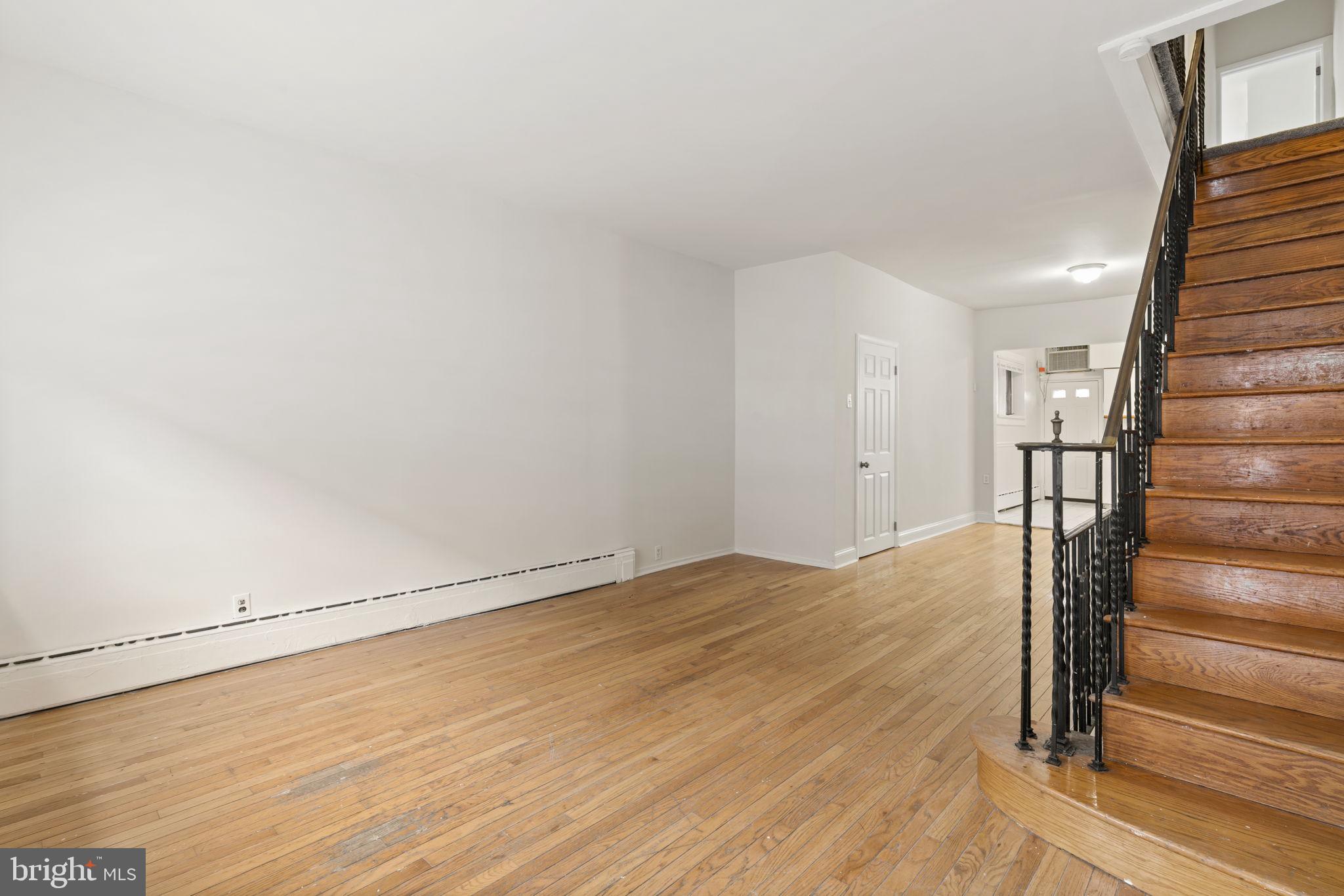 2246 South Hicks Street Philadelphia, PA 19145 - Photo 4 of 26 a view of an empty room with wooden floor and stairs
