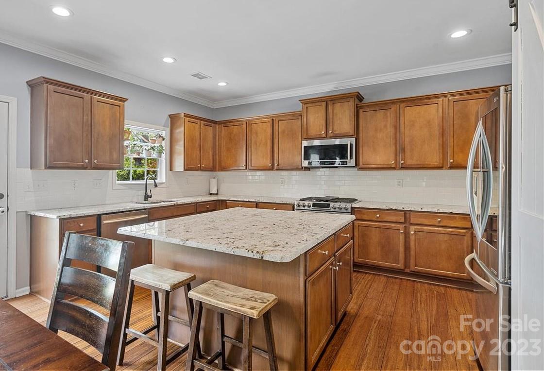 3004 Potomac Road Indian Trail, NC 28079 - Photo 3 of 31 a kitchen with stainless steel appliances granite countertop wooden cabinets a stove top oven a sink and dishwasher with wooden floor